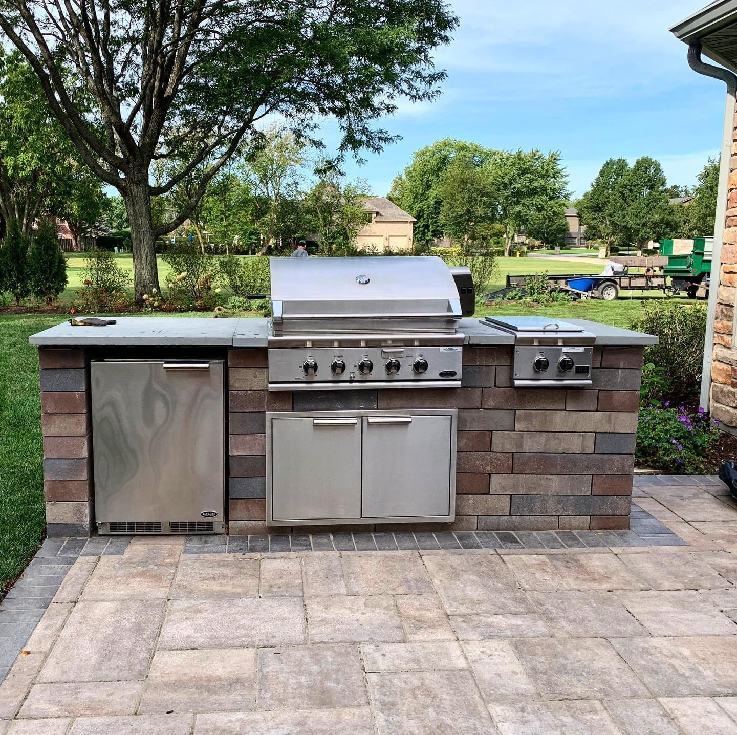 Outdoor Custom Kitchen by The Bravo's Landscape Outdoor Kitchen sitting on a custom Paver Patio, part of a whole Outdoor Living Space