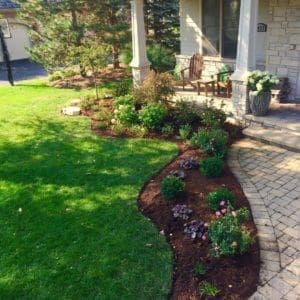 Paver Ssidewalk with mulch and small garden bed accenting the natural beauty of the lawn