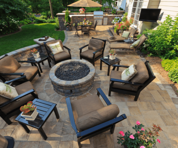 Patio with fire pit, furnitire, plants, and seating wall