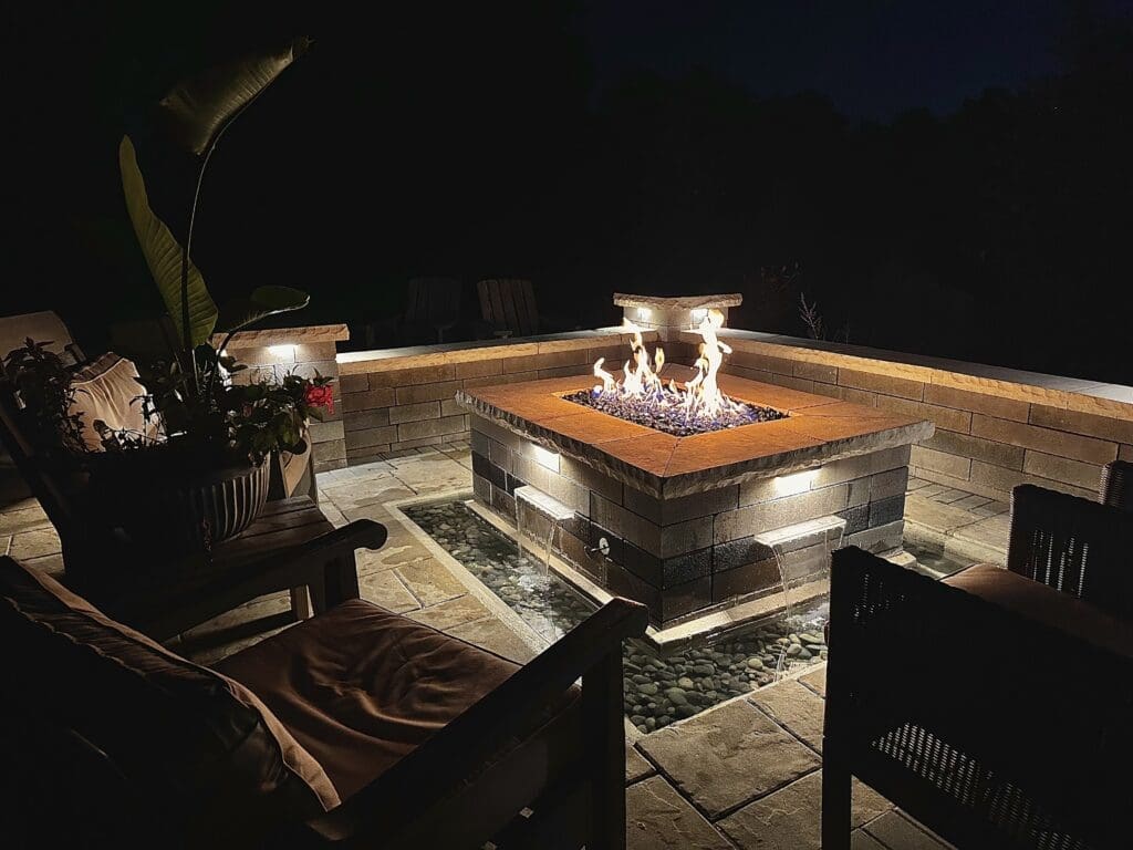 Custom fire pit with built in water fountain surrounding walls and pillars