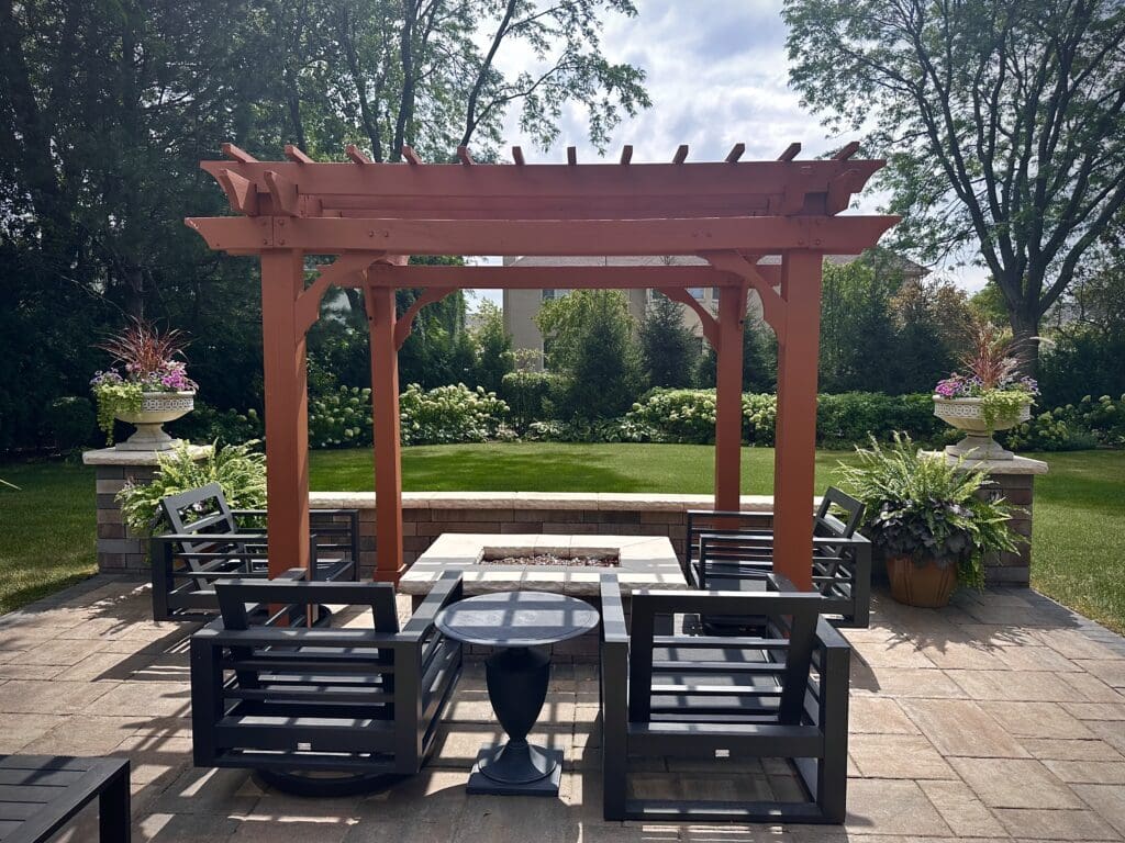 Stained wood pergola on a patio, over a fire pit