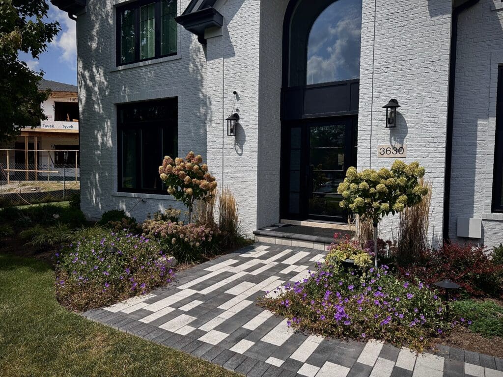 A unique and modern front walkway with black and white Unilock pavers