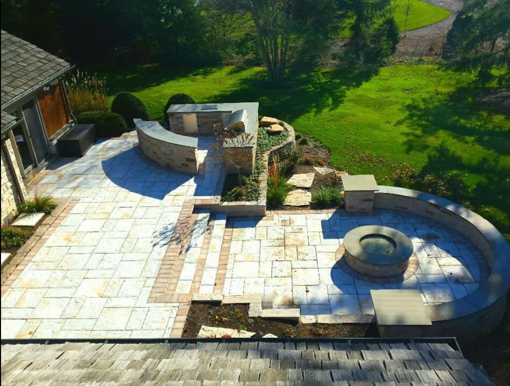 Outdoor Living Space with multi level patio, fire pit, seatl wall, dining area, and outdoor kitchen with grill