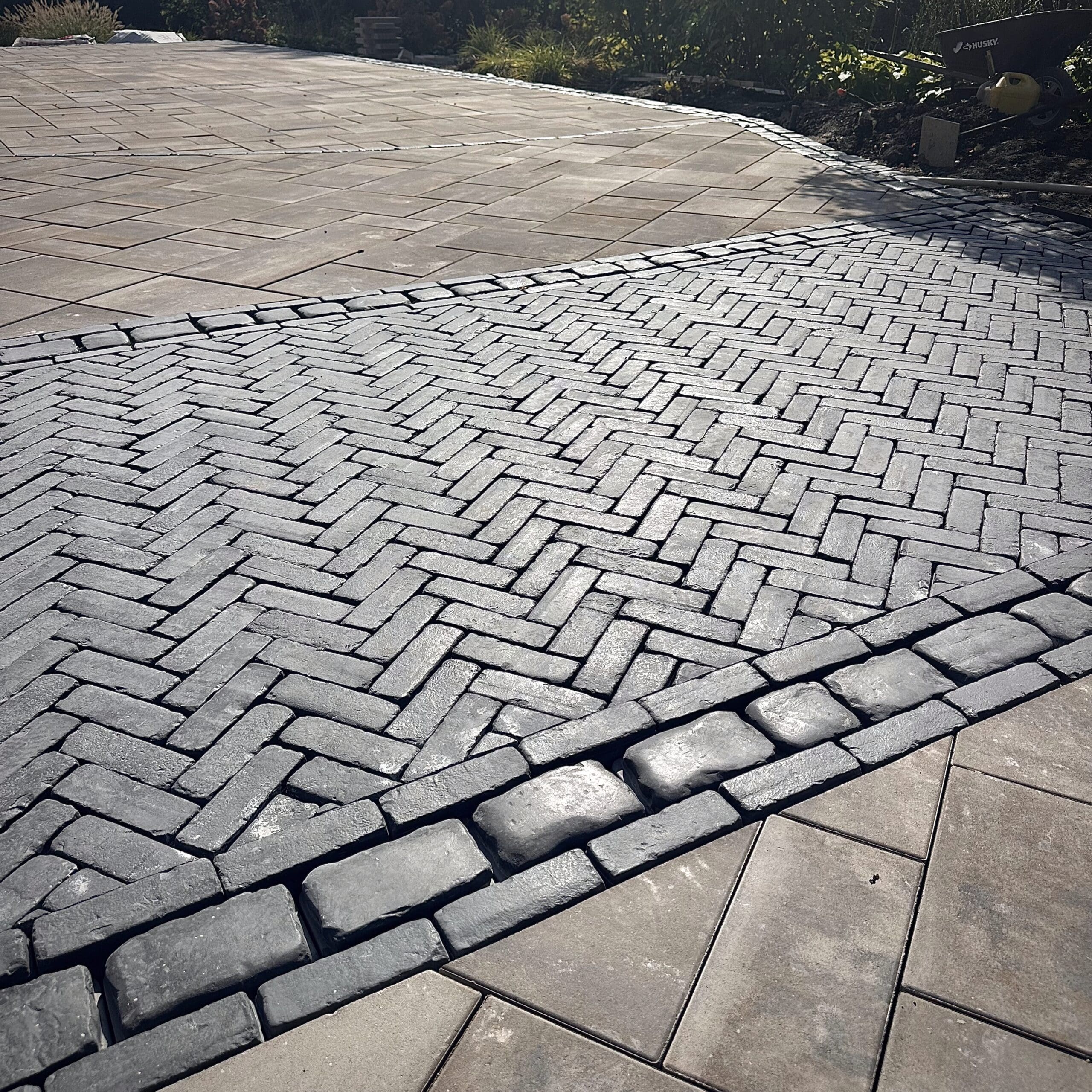 Herringbone Paver Inlay with Cobblestone Border Driveway with Unilock Copthorne herringbone paver inlay bordered by Courtstone cobblestone accents and large format Beacon Hill Smooth pavers.